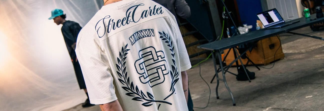 Behind the scenes at a Street Cartel shoot, model wearing the Street Cartel crest jersey